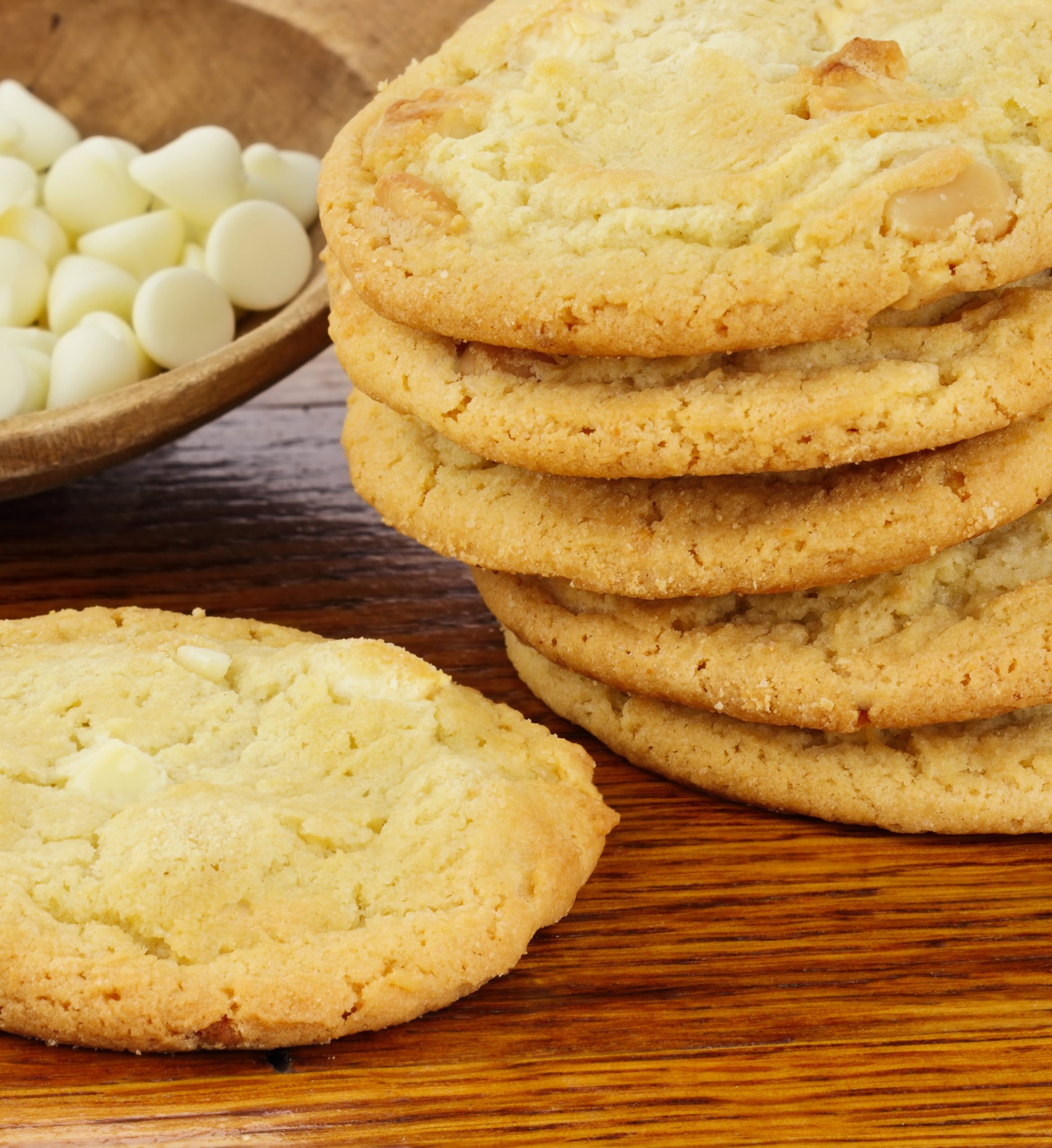 keto white chocolate macademia cookies stacked on wood table