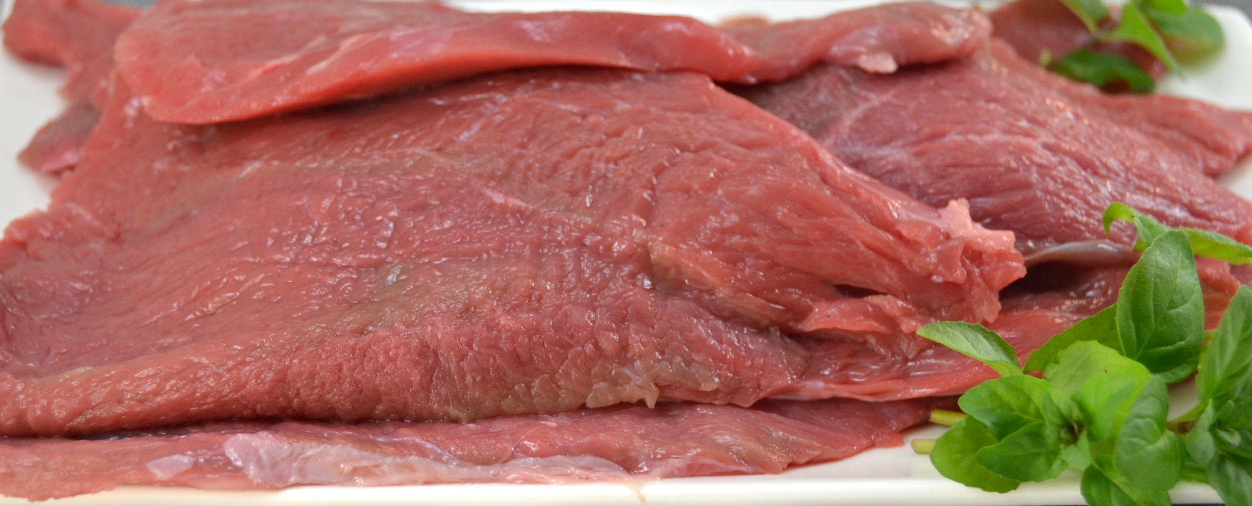 Fresh raw bistec de Palomilla on a white plate