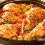 keto Cuban chicken fricassee served in a black cast iron skillet on a wood board