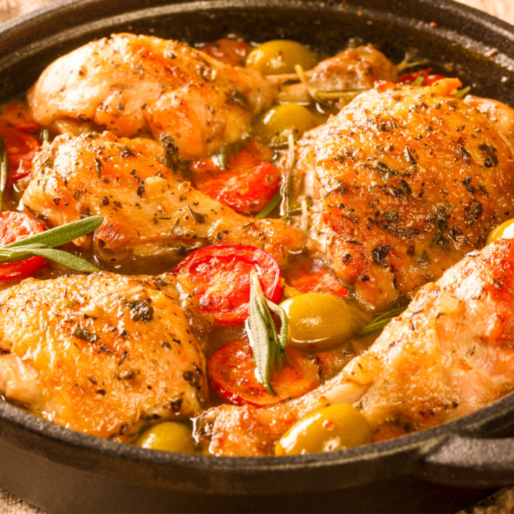 keto Cuban chicken fricassee served in a black cast iron skillet on a wood board