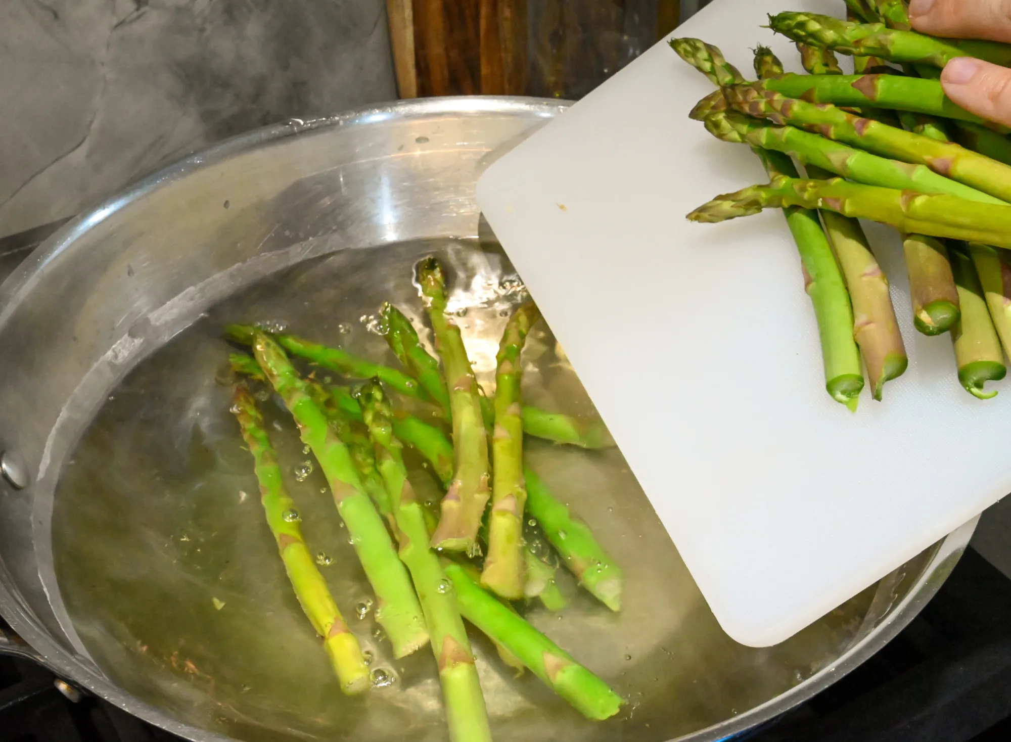 asparagus being blanched in a large wok