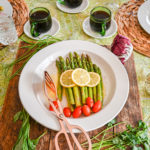keto asparagus salad served on white platter topped with lemon slices and tomatoes
