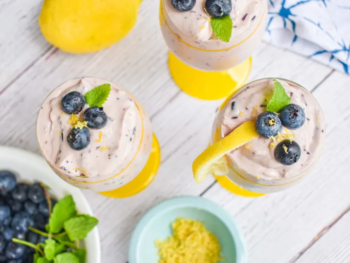 keto blueberry cheesecake mousse with dish of lemon zest and bowl of blueberries and lemon on the side