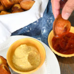keto corn dog minis being dunked in sugar-free ketchup