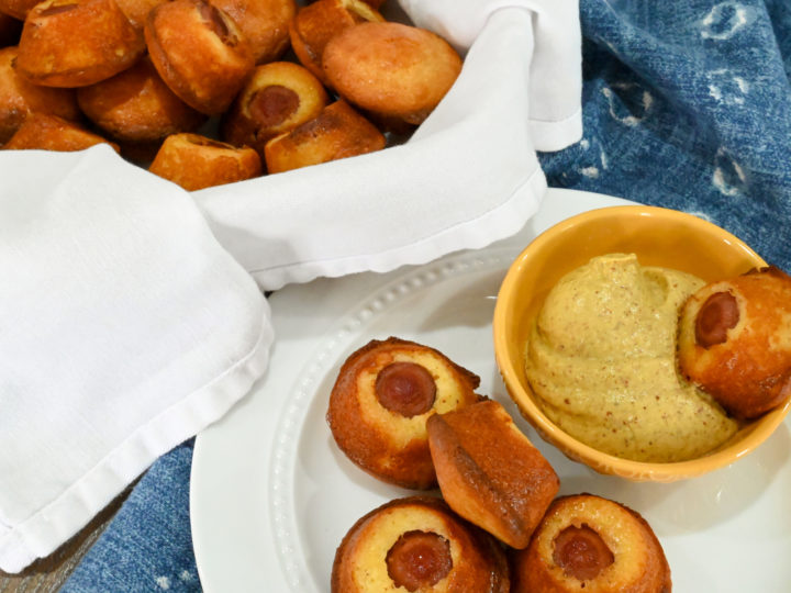 keto corn dog minis in a basket and on a white plate with a side of mustard