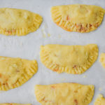 keto ground beef empanadas on parchment paper ready to bake