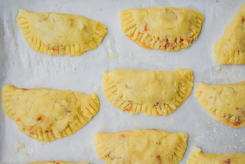 keto ground beef empanadas on parchment paper ready to bake