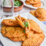 keto ground beef empanadas on white plate up close with more empanandas in the background