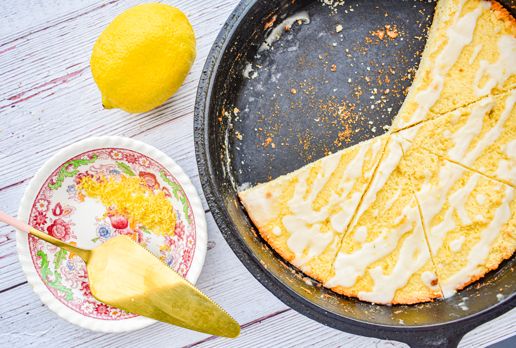 keto lemon ricotta scones in cast iron skillet with dish of lemon zest and lemon on the left