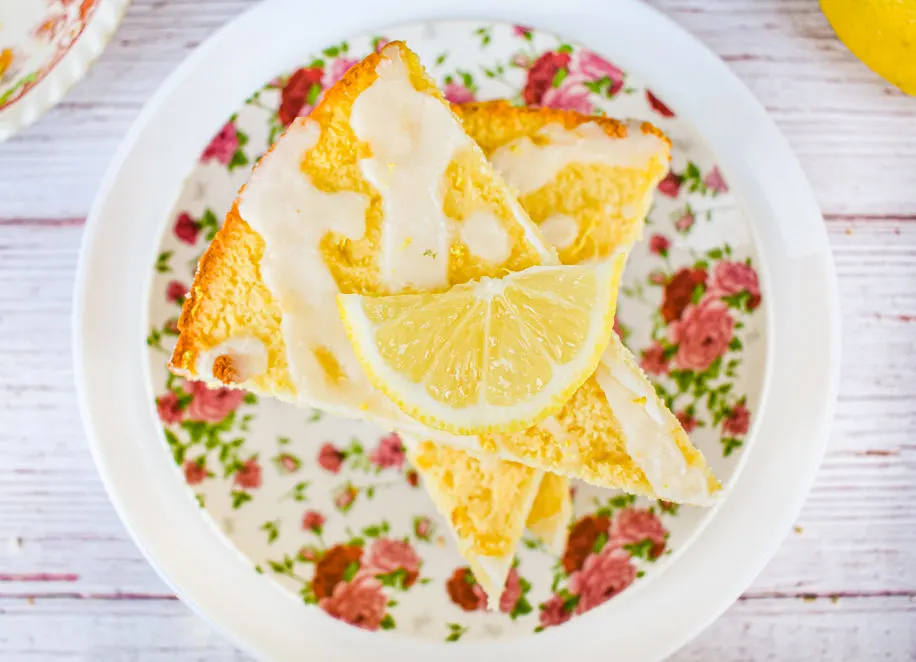 keto lemon ricotta scones with lemon slice on top stacked on pink flower plate