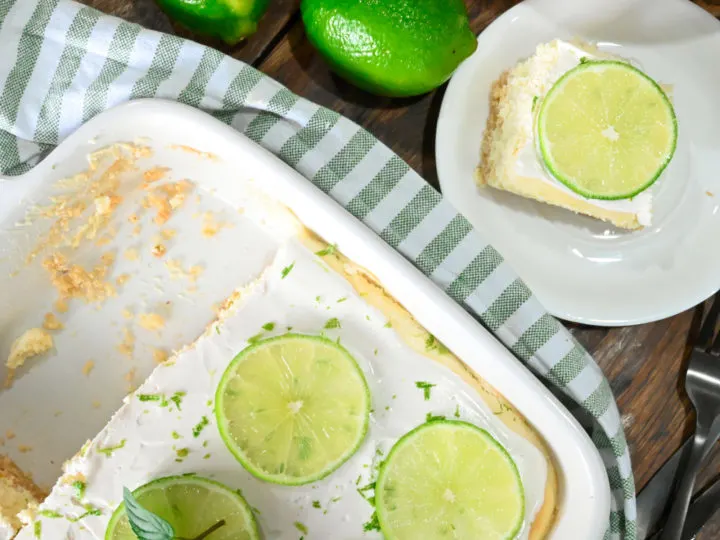 keto lime cheesecake bars sliced and served on wooden board the cheesecake has slices of lime on the top