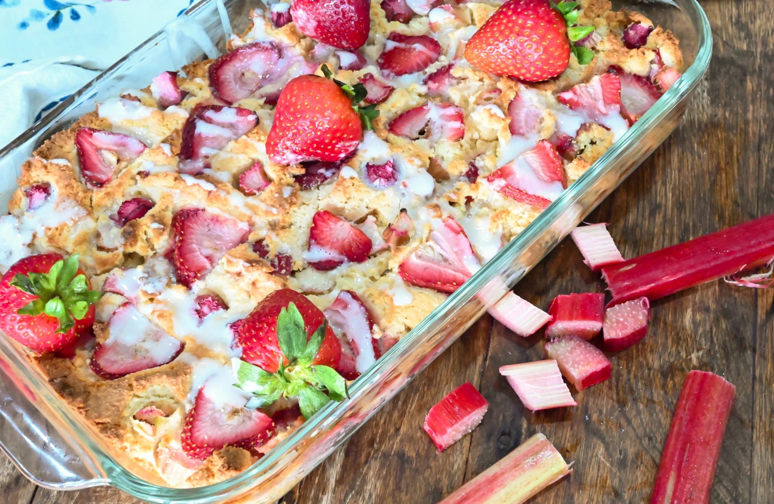 keto strawberry rhubarb topped with vanilla icing in a clear rectangle baking dish