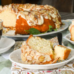 keto almond cake sliced and served on a white plate on top of a cloth napkin
