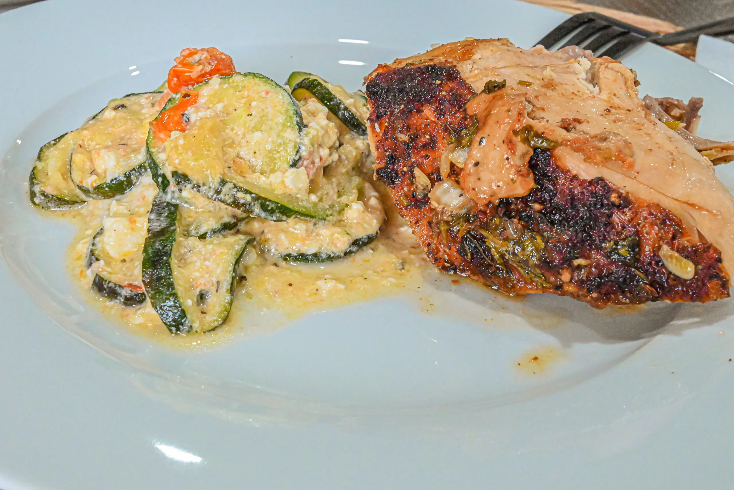 keto baked feta zucchini served with roasted chicken on white plate