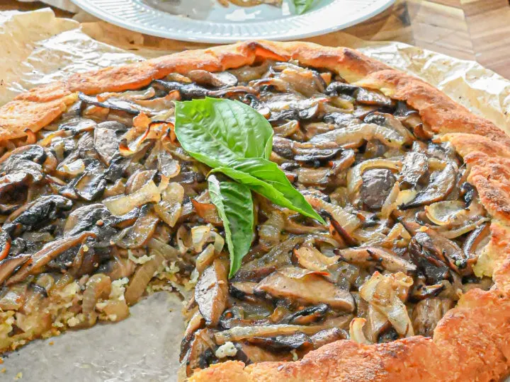 keto mushroom galette with slice removed and white plate with slice and fork in background
