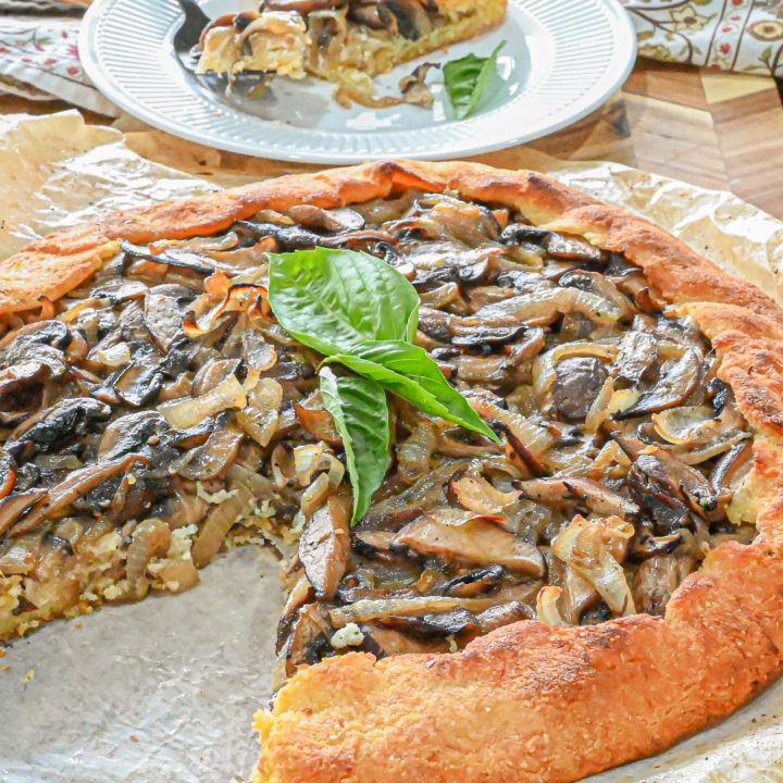 keto mushroom galette with slice removed and white plate with slice and fork in background