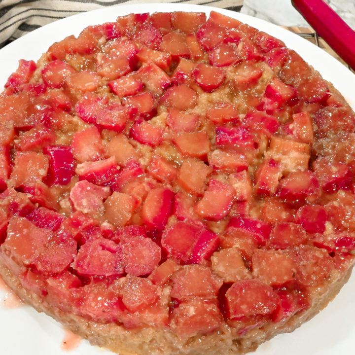 keto rhubarb upside down cake on a white cake plate