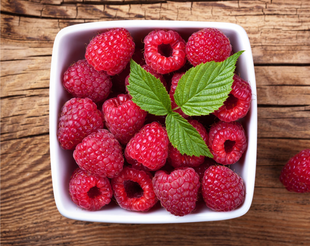 raspberries in a white square container