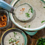 keto cream of mushroom soup about to be ladled into a soup bowl