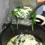 keto cream of spinach soup being ladled into a blender to puree safely