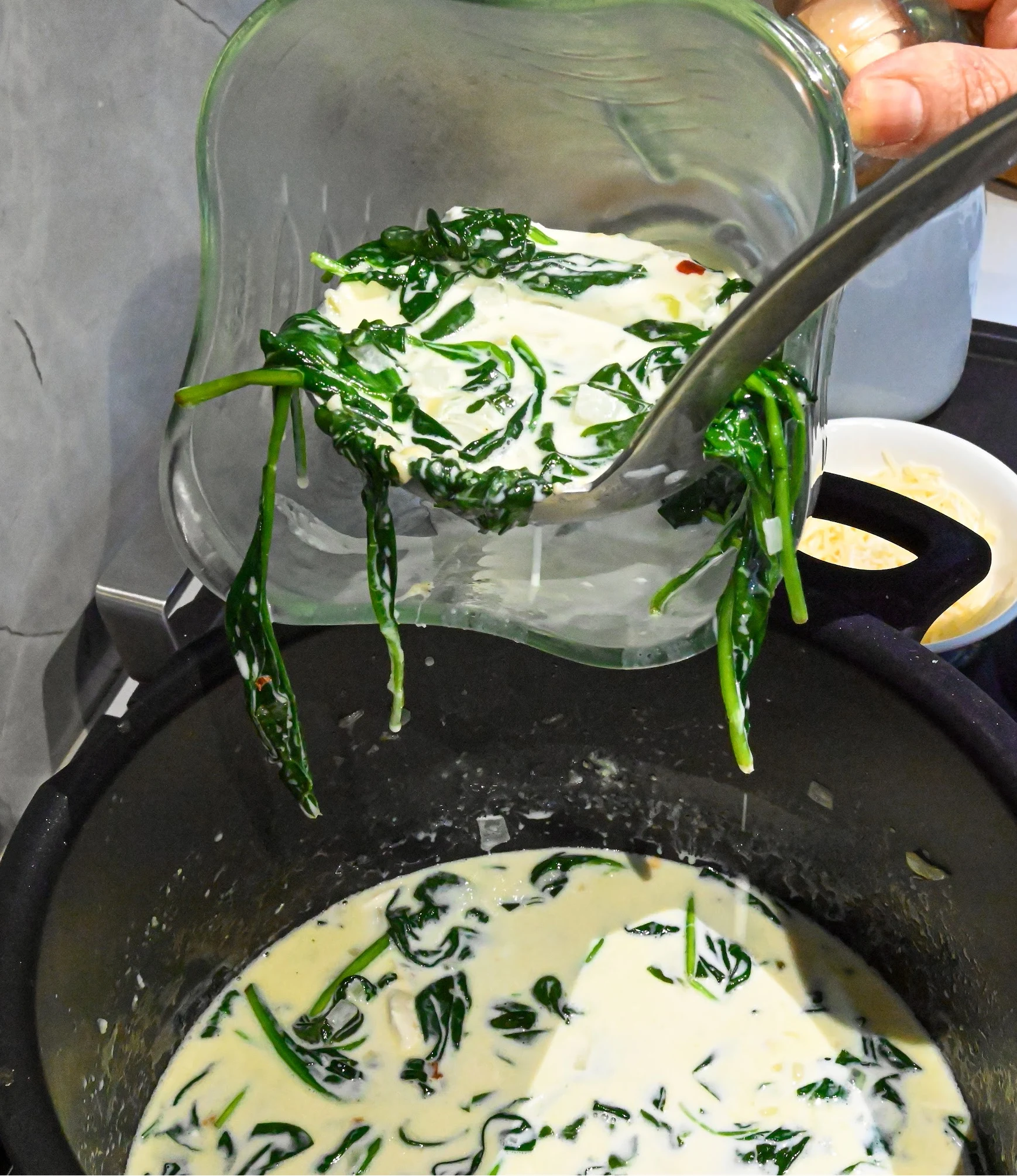 keto cream of spinach soup being ladled into a blender to puree safely