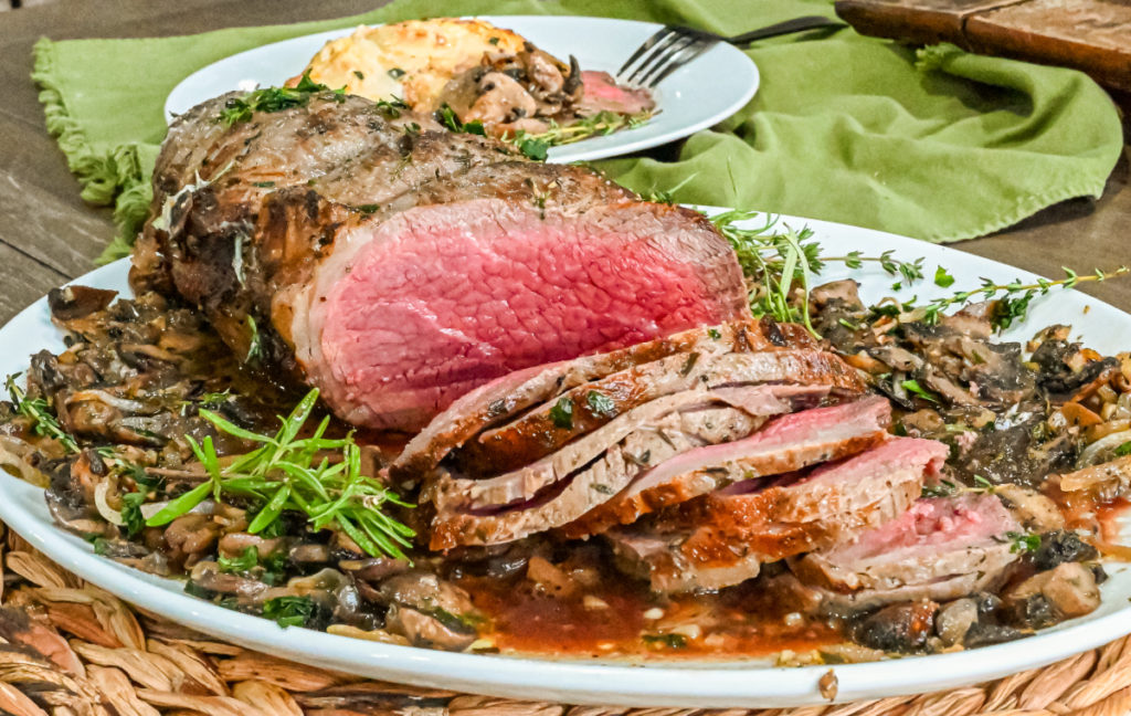 keto garlic herb butter roast sliced and served on white platter