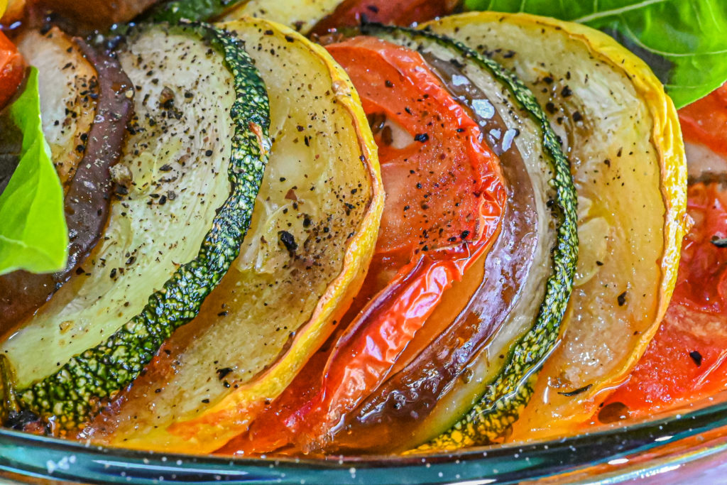 keto ratatouille slices of vegetables close up in clear baking dish