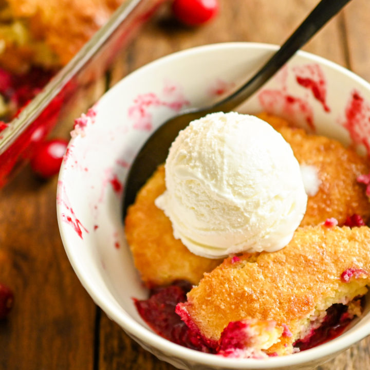 Keto cranberry cobbler served in a small white plate with a scoop of keto vanilla ice cream