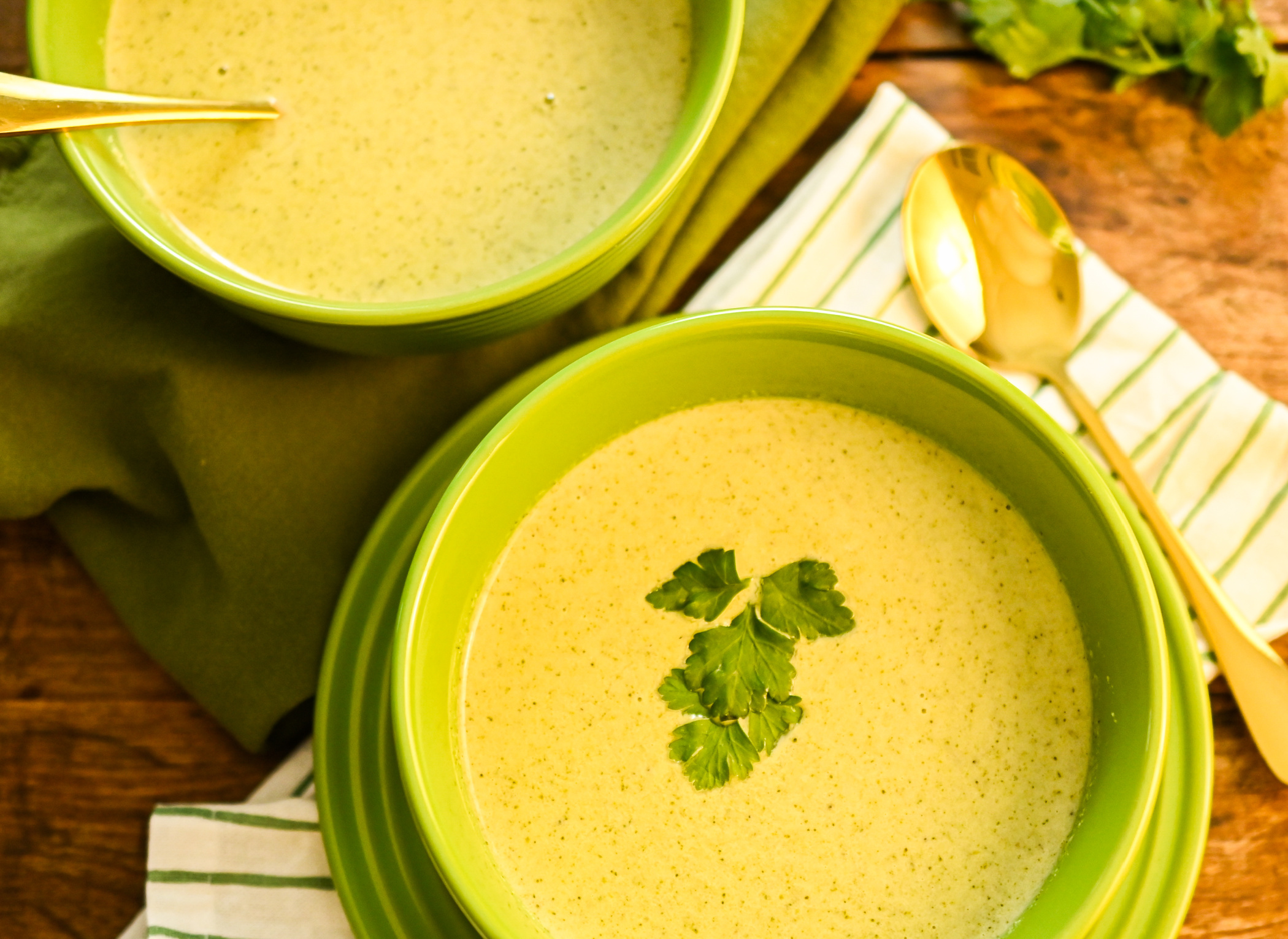 keto cream of broccoli soup served in green bowls