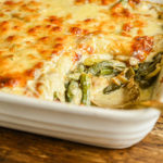 keto green bean casserole in white baking dish with copper spoon