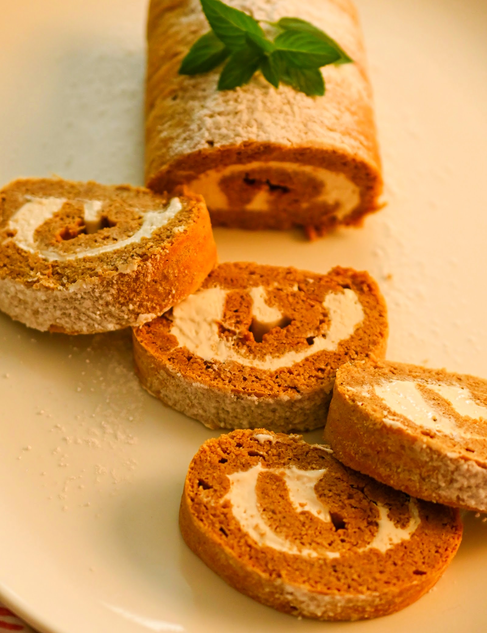 keto pumpkin Swiss roll cake on a white plater