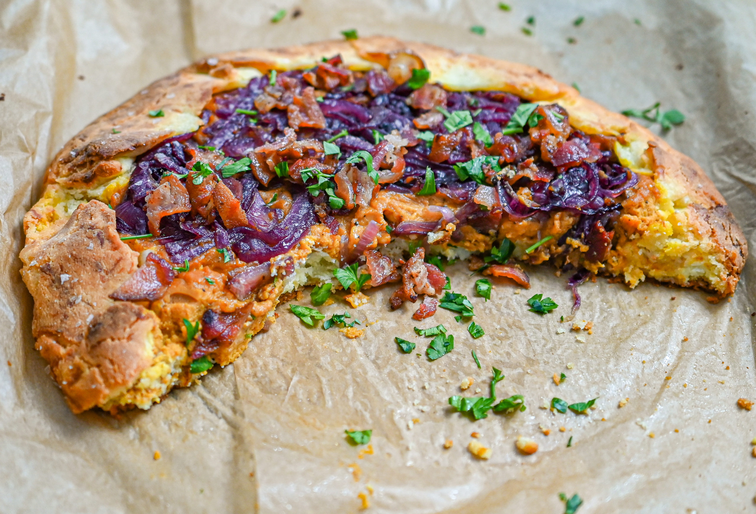 keto savory pumpkin galette on parchment paper with slices removed