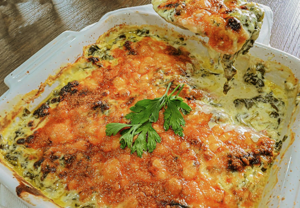 keto creamed spinach in white baking dish being served