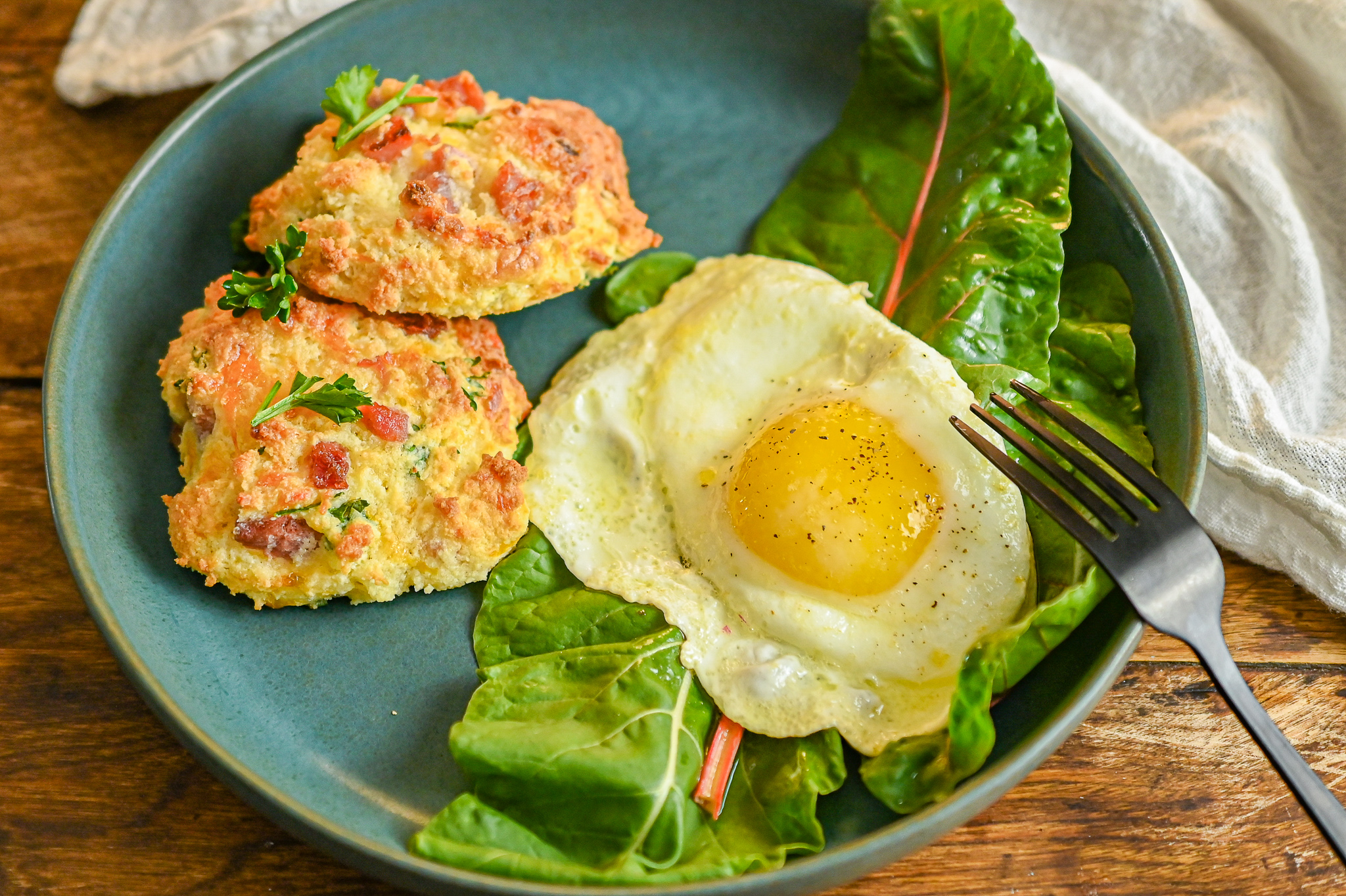 keto ham and cheese drop biscuits served with an over easy egg on blue plate