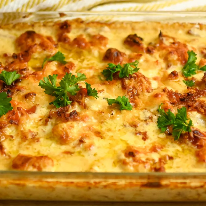 keto roasted cauliflower mac and cheese casserole in a rectangle clear baking dish