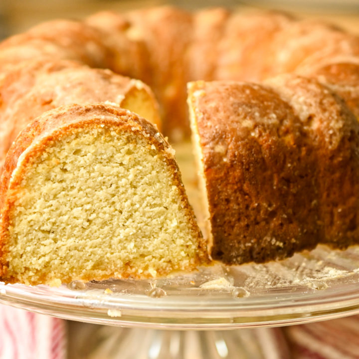 keto rum cake baked in a bundt pan and placed on a glass cake stand