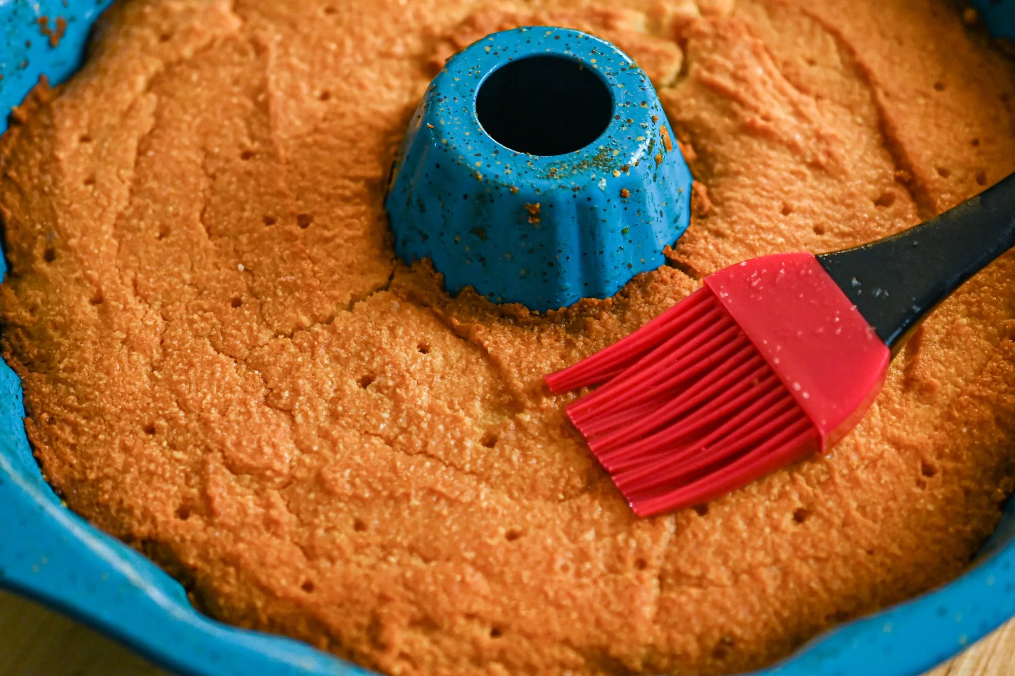 keto rum cake with poked holes ready for the rum sauce