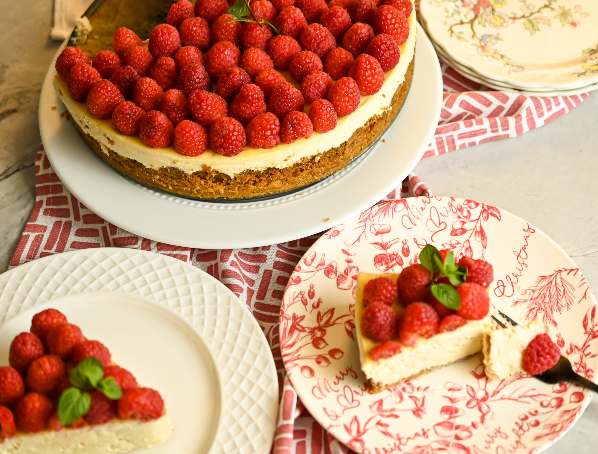 keto white chocolate cheesecake with fresh raspberry topping being served