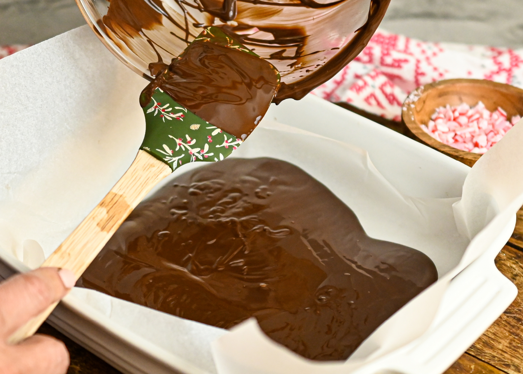 keto chocolate bark being poured into a parchment lined baking pan