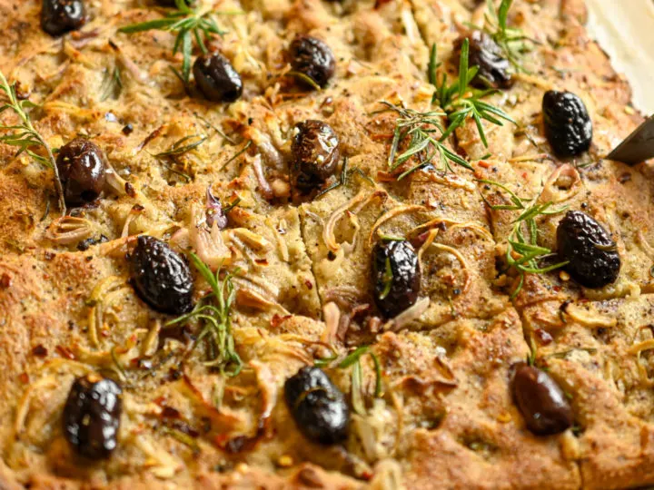 keto focaccia bread topped with black olives and fresh rosemary leaves