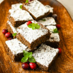 keto gingerbread cake slices stacked on a wood board