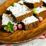 keto gingerbread snack cake sliced on a wood board