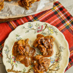 keto pralines on white decorative plate on red plaid napkin with more pralines in background