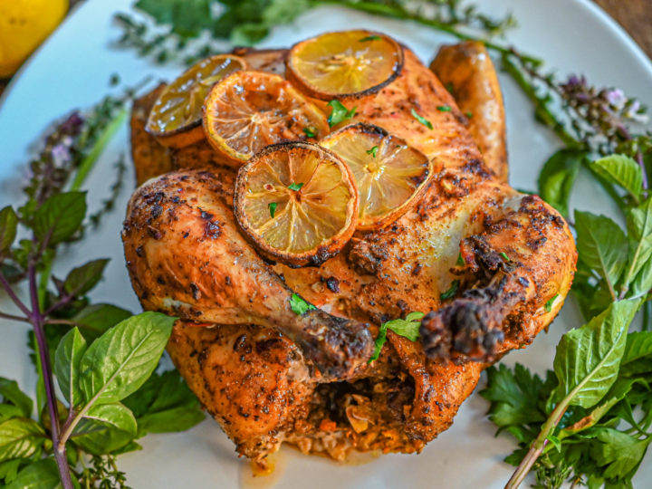 keto sumac harissa chicken on a white plater with herbs