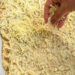 sprinking cheese on keto garlic bread before baking