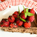 Slice of keto chocolate raspberry cheesecake served on a white and red plate