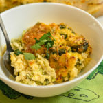 keto broccoli cauliflower rice casserole served in a small white bowl with a black spoon