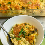 keto broccoli cauliflower rice casseroleserved in small white bowl with casserole dish in thr background