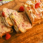 keto raspberry bread loaf sliced on wood board