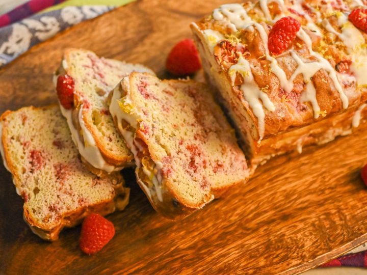 keto raspberry bread loaf sliced on wood board